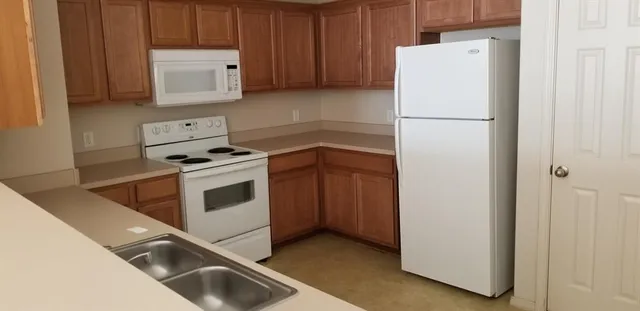 a kitchen with a refrigerator sink stove and cabinets