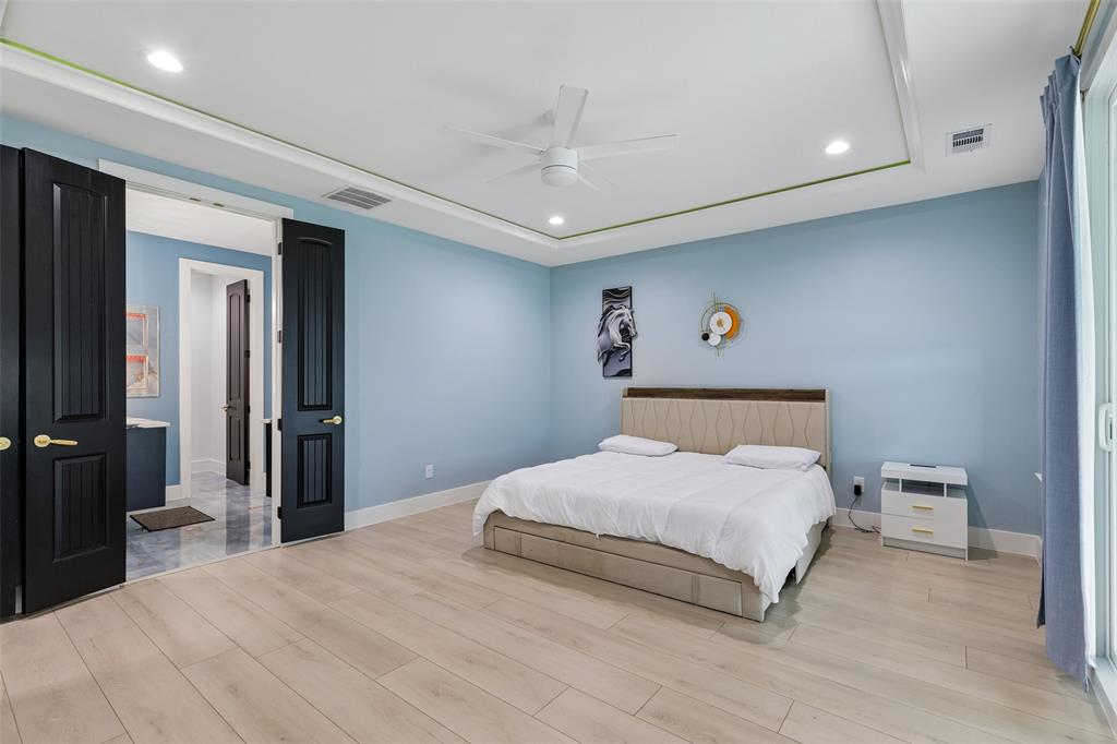 1053 Sedalia Road Van Alstyne, TX 75495 - Photo 27 of 40 a bedroom with a large bed and a chandelier
