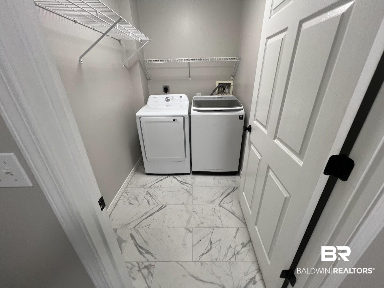 266 Ridgewood Drive Daphne, AL 36526 - Photo 25 of 34 Dedicated laundry space featuring patterned tile flooring, light gray walls, and white wire shelving