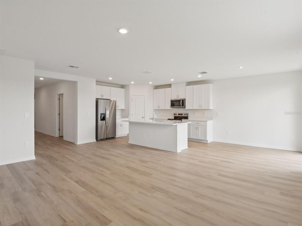 1655 Bark Rdg Drive Auburndale, FL 33823 - Photo 3 of 21 a view of kitchen with kitchen island wooden floor granite counter tops and white cabinets