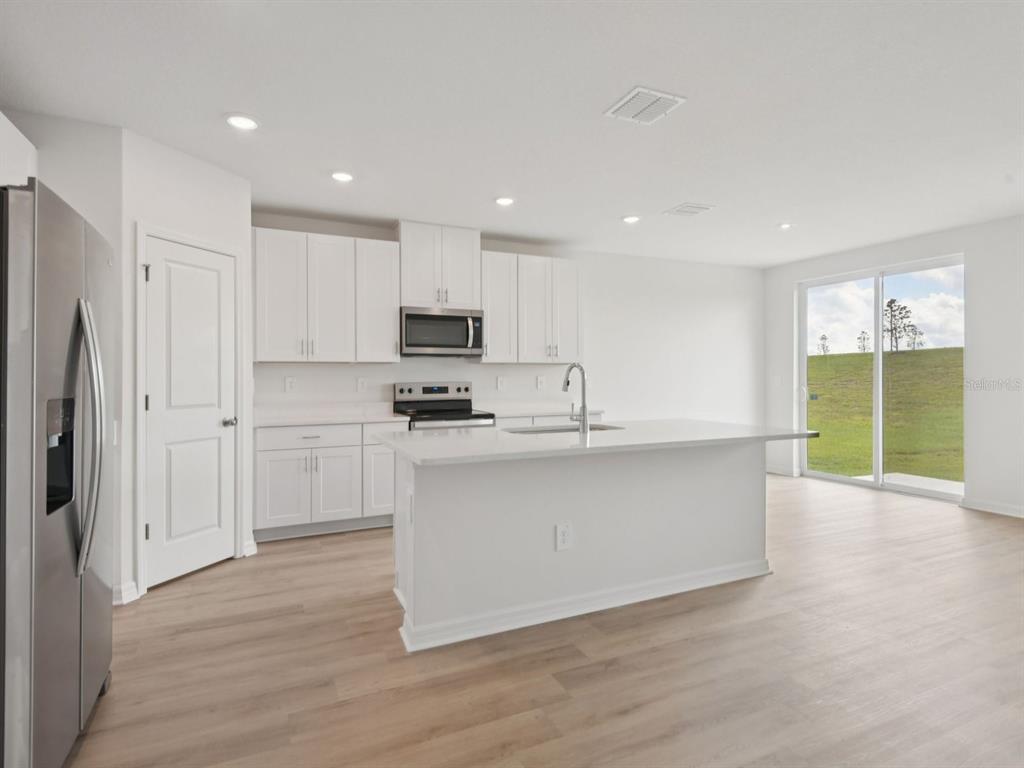 1655 Bark Rdg Drive Auburndale, FL 33823 - Photo 7 of 21 a kitchen with white cabinets and stainless steel appliances