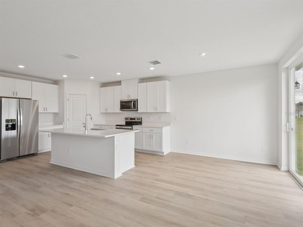 1655 Bark Rdg Drive Auburndale, FL 33823 - Photo 9 of 21 a kitchen with white cabinets and stainless steel appliances