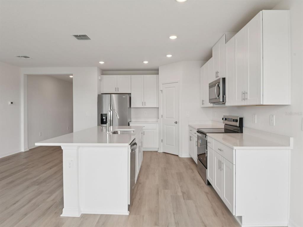 1655 Bark Rdg Drive Auburndale, FL 33823 - Photo 10 of 21 a large kitchen with stainless steel appliances lots of counter space and wooden floor