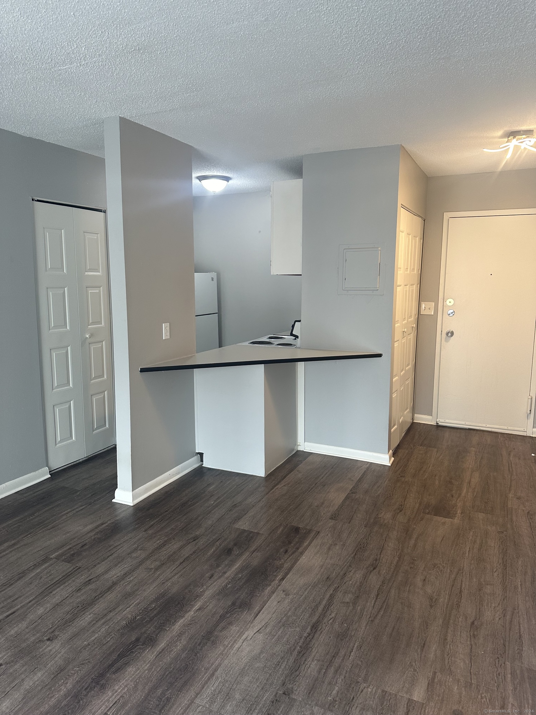 3 Unit 61 Middletown Court, Unit STUDIO Middletown, CT 06457 - Photo 1 of 5 wooden floor in an empty room with a kitchen