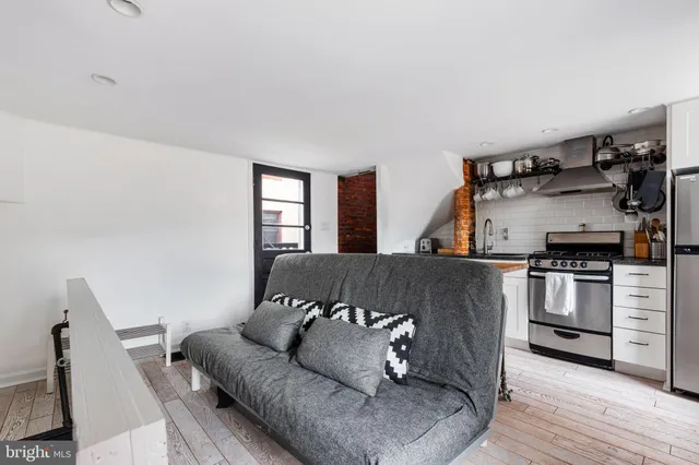 a living room with furniture and kitchen