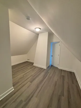an empty room with wooden floor and white walls