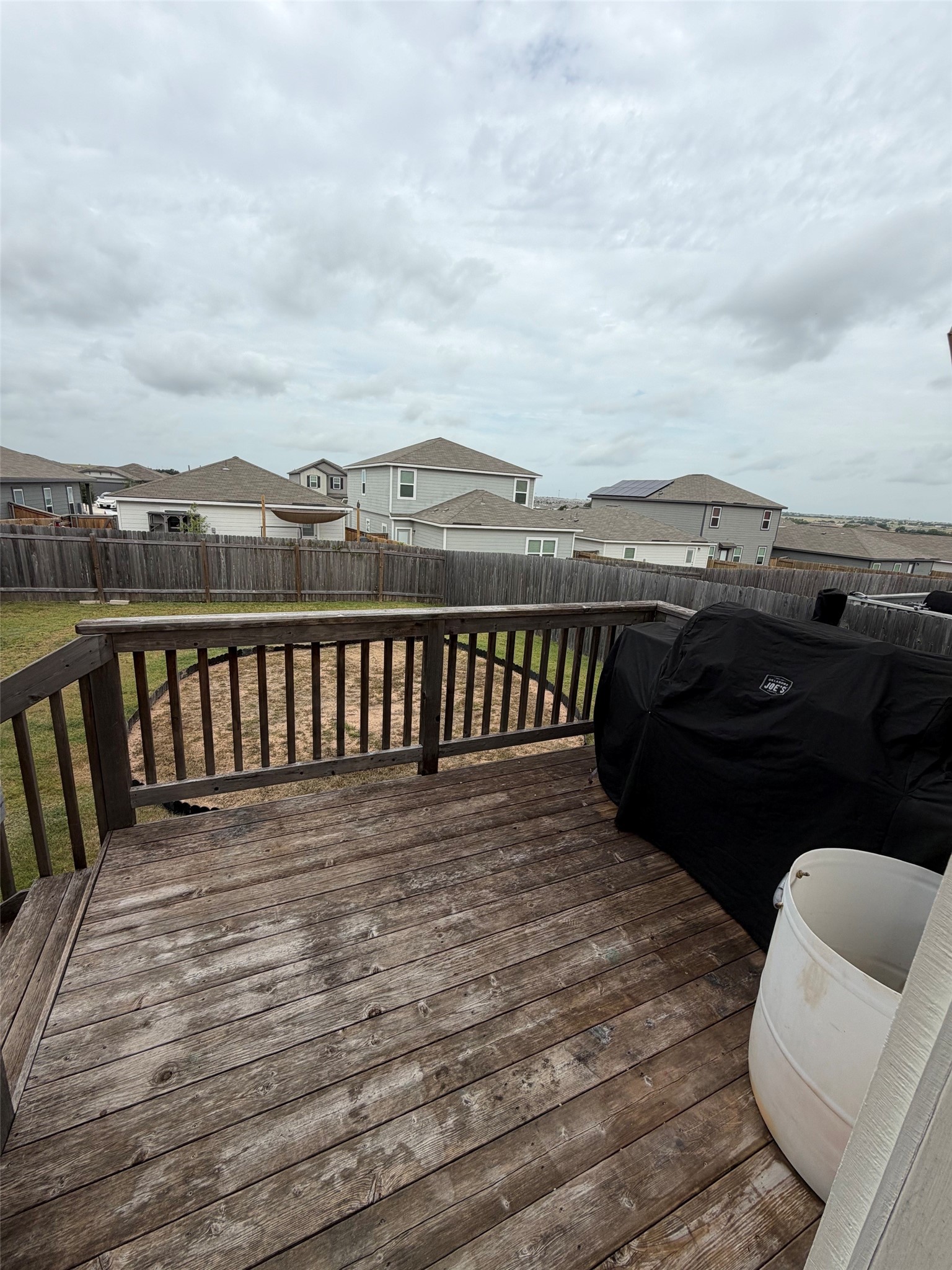 229-1 Night Riders Way Jarrell, TX 76537 - Photo 21 of 21 A spacious wooden deck provides ample outdoor living space, overlooking a fenced backyard and neighborhood.