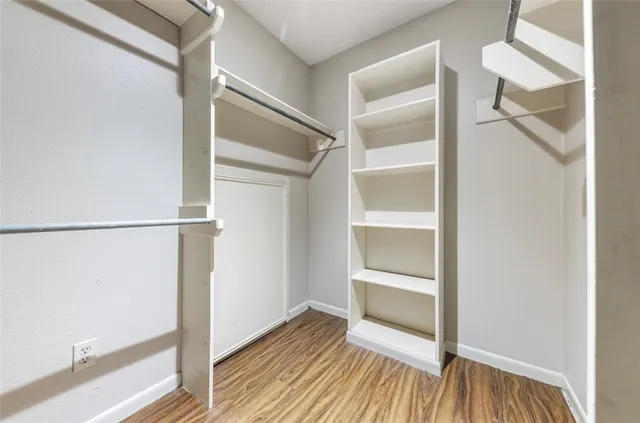 a view of walk in closet with empty racks