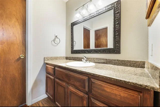 a bathroom with a granite countertop sink and a mirror