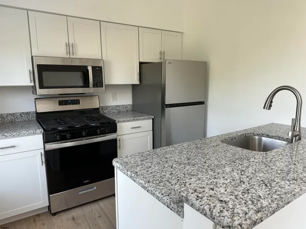 a kitchen with stainless steel appliances granite countertop a sink stove and refrigerator