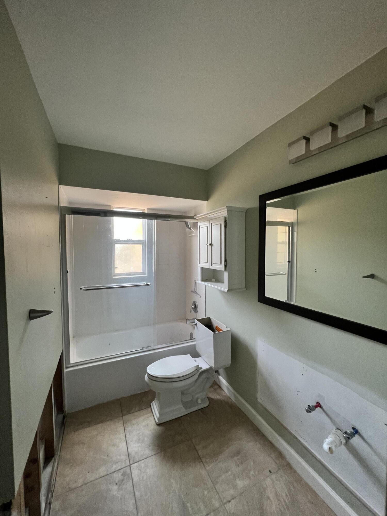 2392 Clipper Way Naples, FL 34104 - Photo 20 of 29 a bathroom with a sink a toilet and mirror