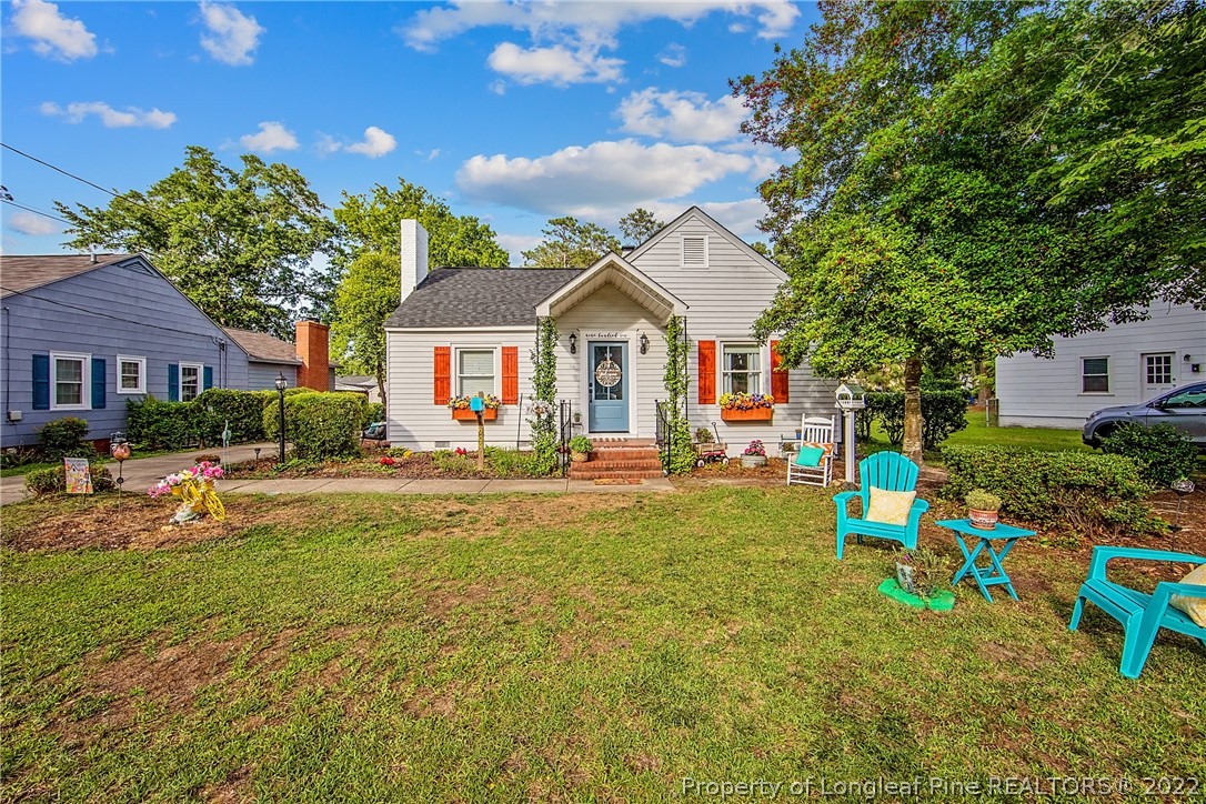 a view of house with outdoor seating and yard