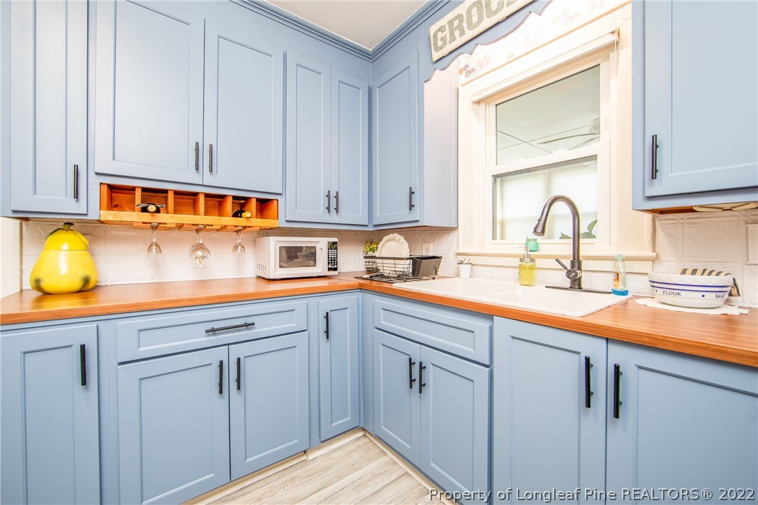 906 McKimmon Road Fayetteville, NC 28303 - Photo 15 of 33 a kitchen with stainless steel appliances granite countertop a sink and cabinets with wooden floor
