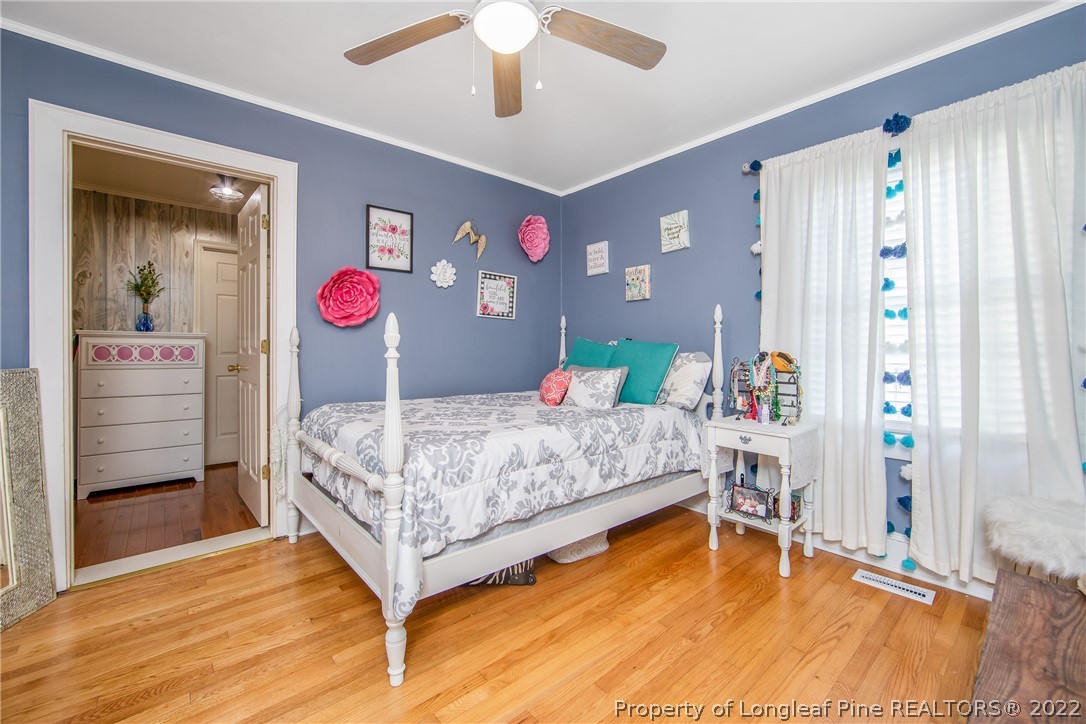 906 McKimmon Road Fayetteville, NC 28303 - Photo 25 of 33 a bedroom with a bed and a chandelier