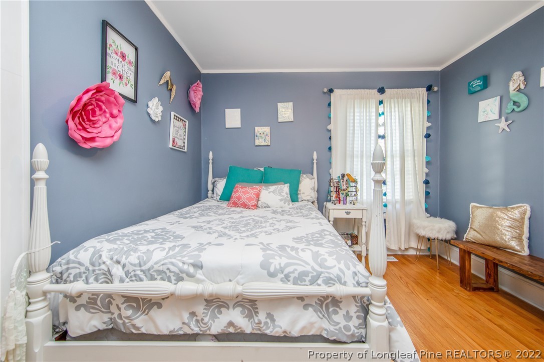 906 McKimmon Road Fayetteville, NC 28303 - Photo 26 of 33 a bedroom with a bed and wooden floor