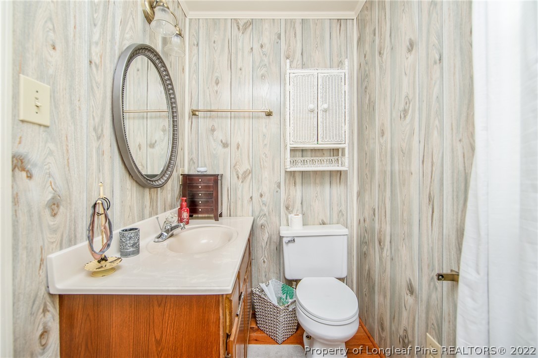 906 McKimmon Road Fayetteville, NC 28303 - Photo 29 of 33 a bathroom with a sink a toilet and a mirror