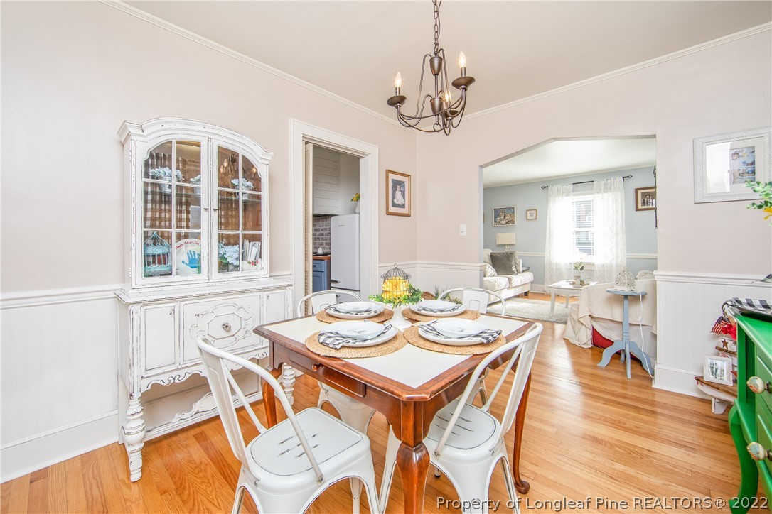 906 McKimmon Road Fayetteville, NC 28303 - Photo 10 of 33 a view of a dining room with furniture wooden floor and chandelier