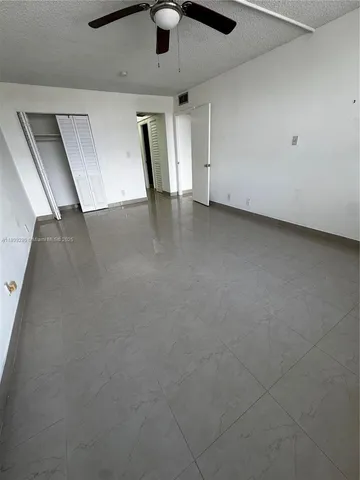 a view of an empty room with a ceiling fan