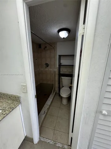 a bathroom with a granite countertop shower and a sink