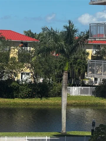 a view of swimming pool with lawn chairs under an umbrella