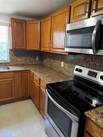 a kitchen with stainless steel appliances granite countertop a stove and a microwave