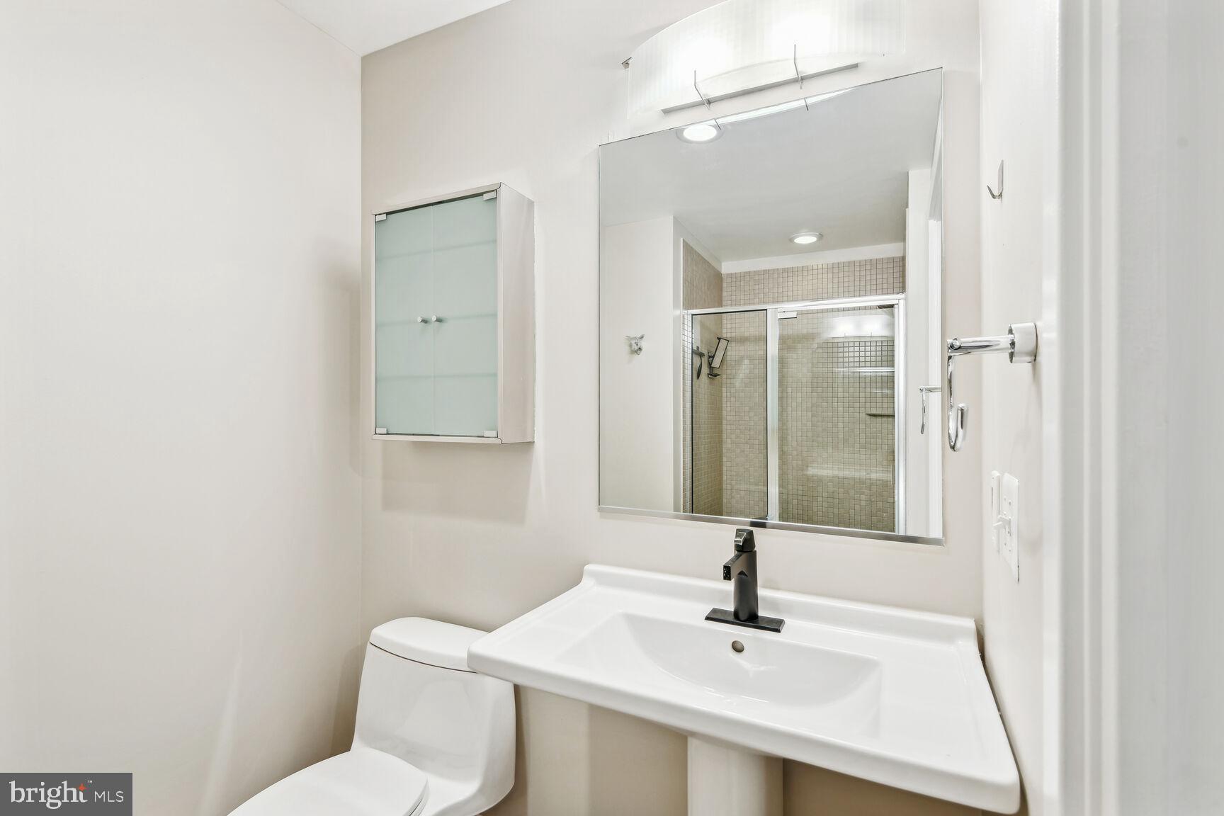 2125 14th Street Northwest, Unit 319 Washington, DC 20009 - Photo 13 of 23 a bathroom with a sink toilet and mirror