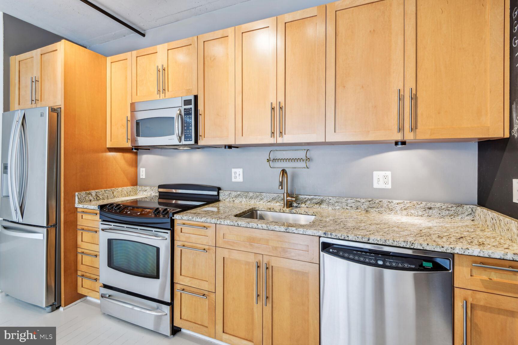 2125 14th Street Northwest, Unit 319 Washington, DC 20009 - Photo 6 of 23 a kitchen with granite countertop white cabinets and stainless steel appliances