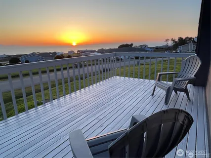 a view of a roof deck with chair and wooden floor