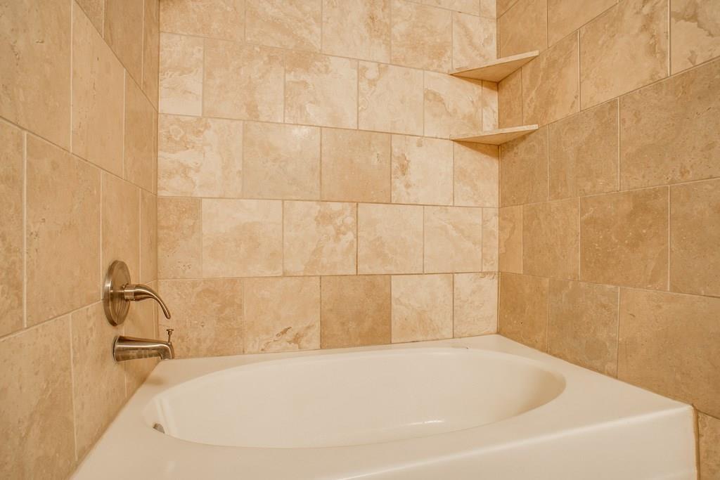3102 Kings Road, Unit 3310 Dallas, TX 75219 - Photo 16 of 19 a white bath tub sitting in a bathroom