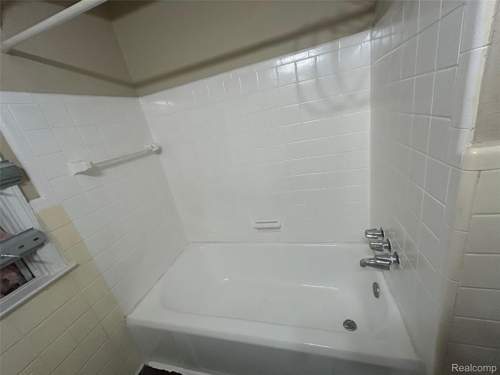 16824 Rutherford Street Detroit, MI 48235 - Photo 16 of 25 White porcelain bathtub with chrome fixtures and white subway tile surround