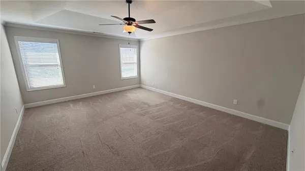 en empty room with windows and chandelier fan
