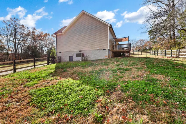 a view of a house with backyard garden and trees
