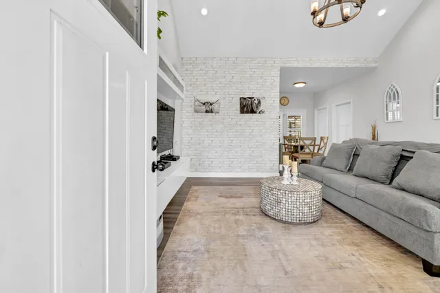 a living room with furniture and a to ceiling window