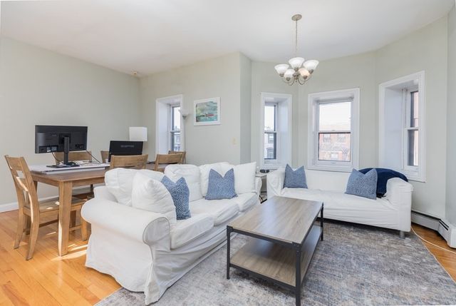 a living room with furniture a dining table and a fireplace