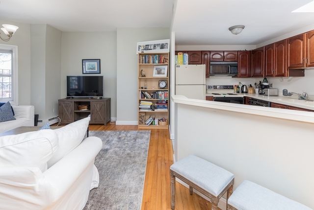 a kitchen with stainless steel appliances kitchen island a refrigerator sink and cabinets