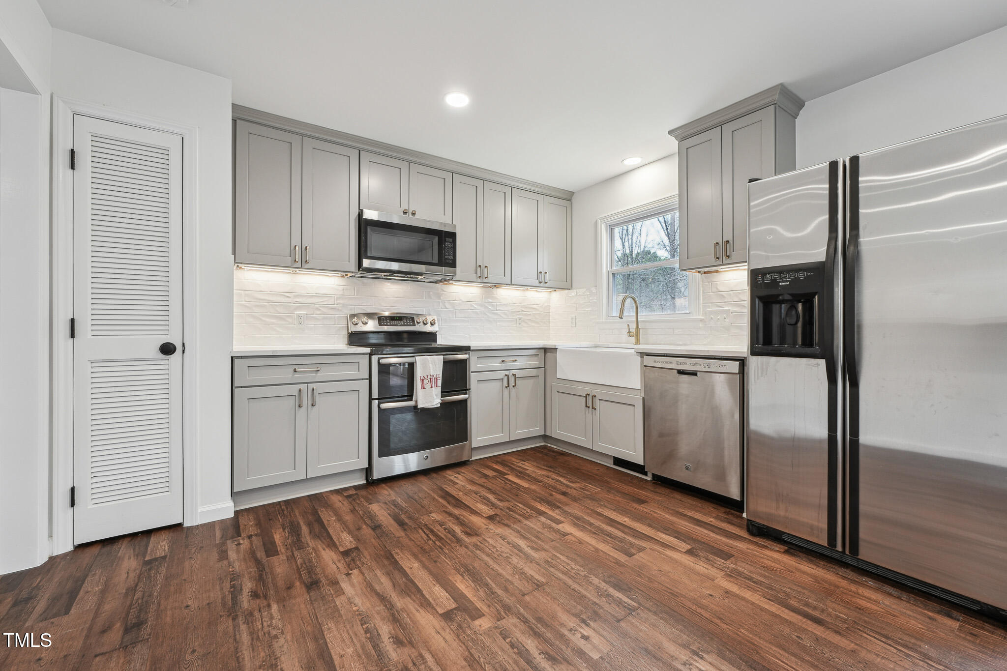 109 Chatterson Drive Raleigh, NC 27615 - Photo 13 of 51 a kitchen with white cabinets stainless steel appliances and wooden floor
