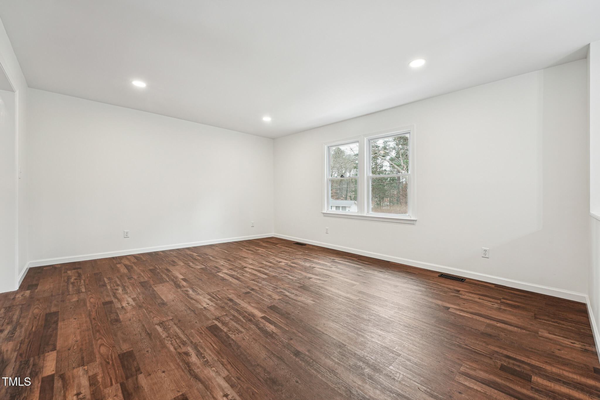 109 Chatterson Drive Raleigh, NC 27615 - Photo 6 of 51 an empty room with wooden floor and windows