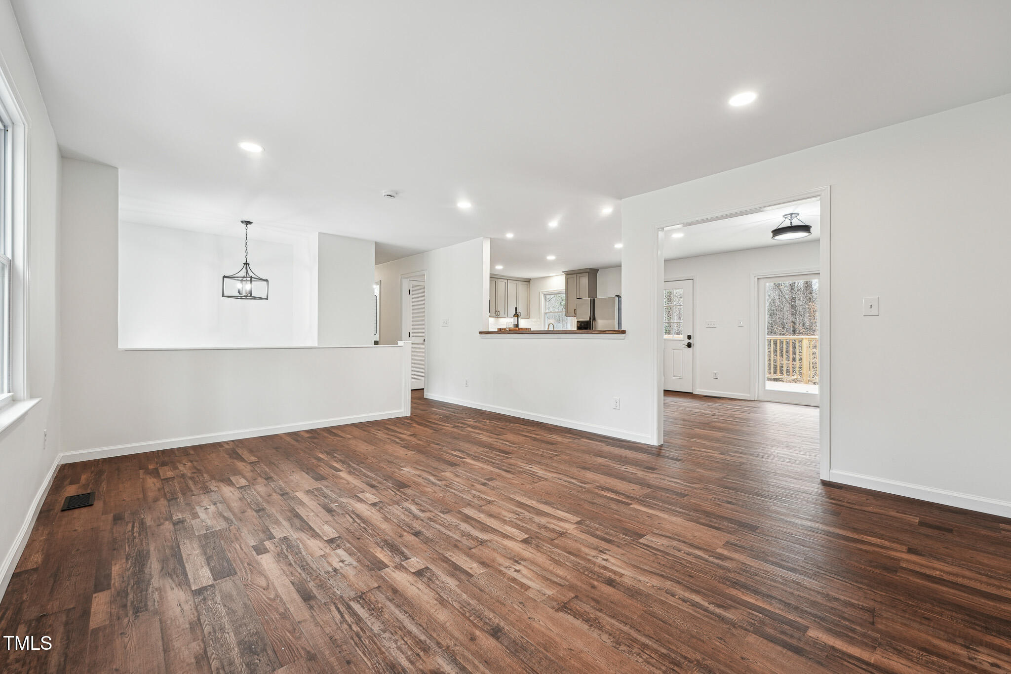 109 Chatterson Drive Raleigh, NC 27615 - Photo 8 of 51 a view of empty room with wooden floor and kitchen