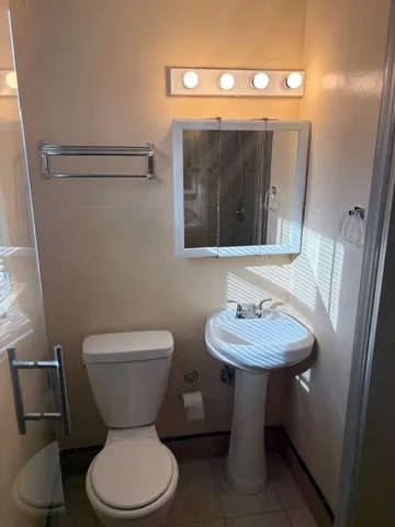 a bathroom with a toilet sink and mirror
