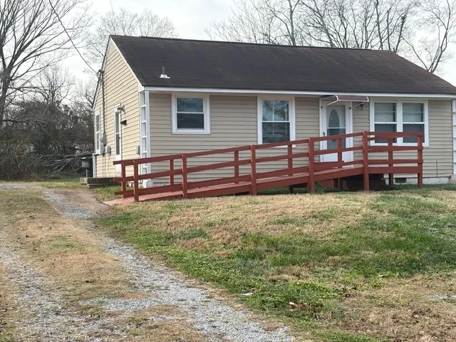 a backyard of a house with wooden fence and large trees