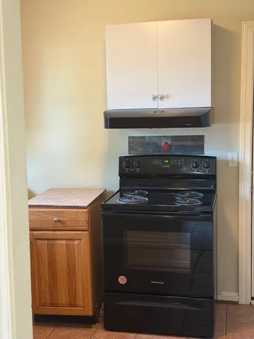 a stove top oven sitting inside of a kitchen
