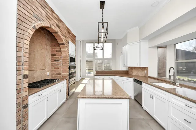a kitchen with granite countertop a sink and cabinets