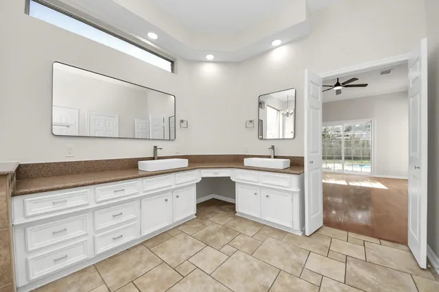 a spacious bathroom with a granite countertop sink mirror and