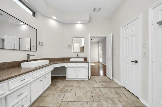 a large white kitchen with a sink and dishwasher a stove with white cabinets