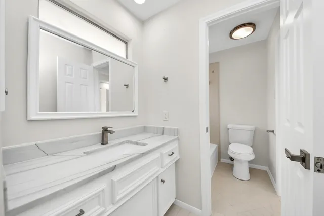 a bathroom with a sink a toilet and a mirror