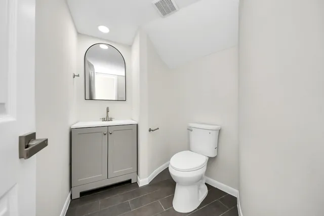a bathroom with a toilet sink and mirror