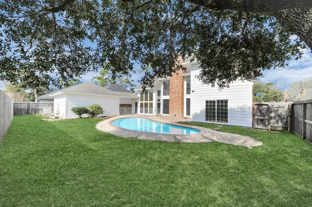 a view of a house with a swimming pool and a yard