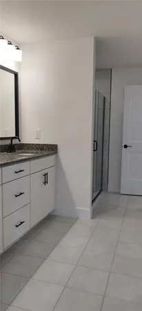 a spacious bathroom with a granite countertop sink and a mirror