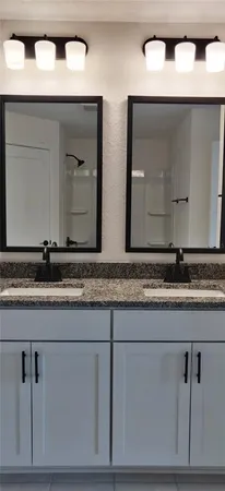 a bathroom with mirror and vanity