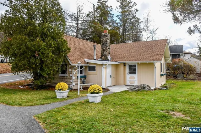 a front view of a house with a yard and trees